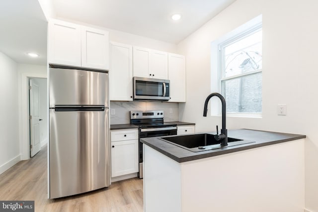 kitchen featuring sink, light hardwood / wood-style flooring, stainless steel appliances, and white cabinets