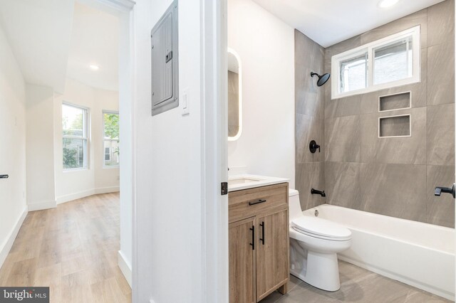 full bathroom with a healthy amount of sunlight, vanity, toilet, and tiled shower / bath combo