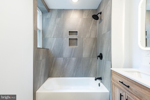 bathroom with vanity and tiled shower / bath