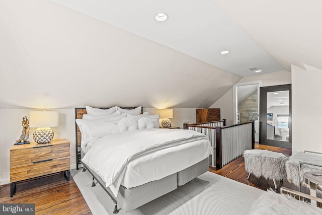 bedroom with lofted ceiling and dark hardwood / wood-style floors