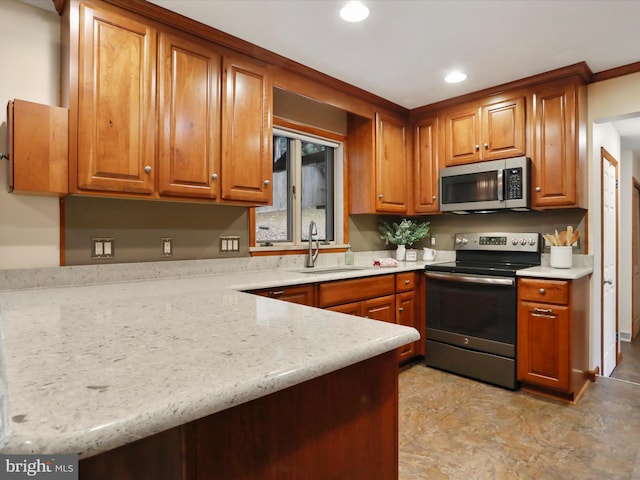 kitchen with appliances with stainless steel finishes, sink, and light stone counters