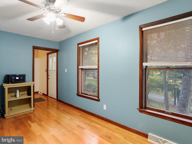 empty room with ceiling fan and light hardwood / wood-style floors