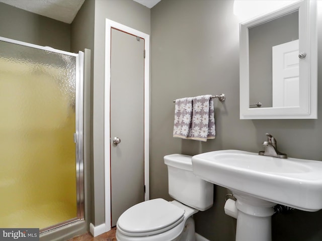 bathroom with a shower with shower door and toilet