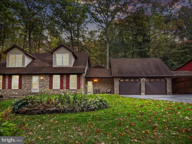 cape cod home with a garage and a lawn