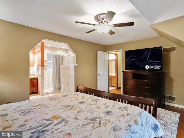 bedroom featuring ceiling fan, hardwood / wood-style flooring, and ensuite bathroom