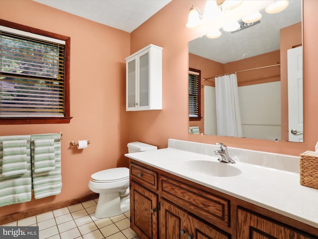 bathroom with tile patterned flooring, a notable chandelier, vanity, and toilet