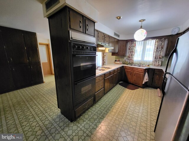 kitchen featuring decorative light fixtures and dark brown cabinetry