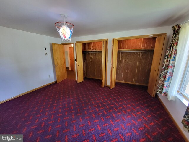 unfurnished bedroom featuring ceiling fan and dark colored carpet