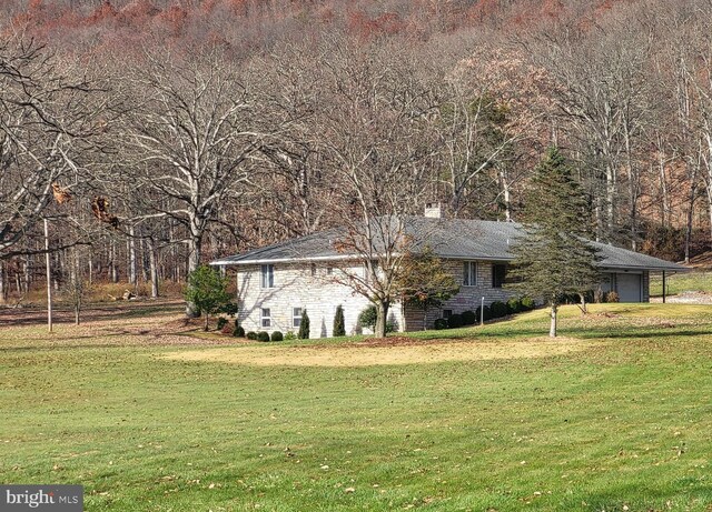133 Morral Dr, Everett, PA 15537 - view of side of property featuring a yard, a garage, and a chimney