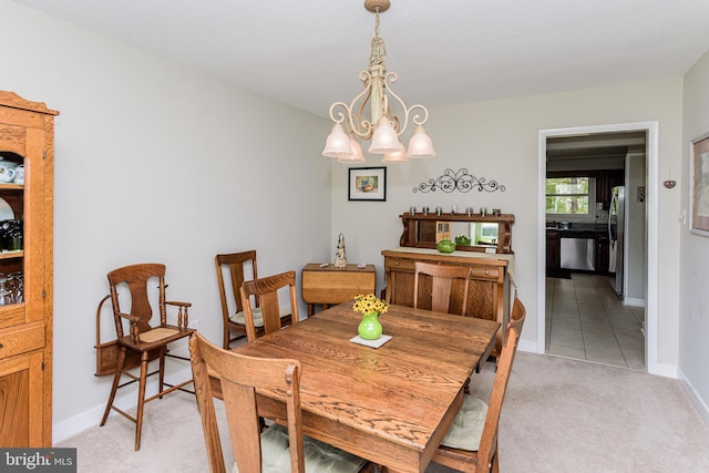 carpeted dining room with an inviting chandelier