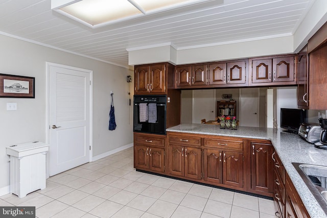 kitchen featuring black oven, ornamental molding, and light tile patterned floors