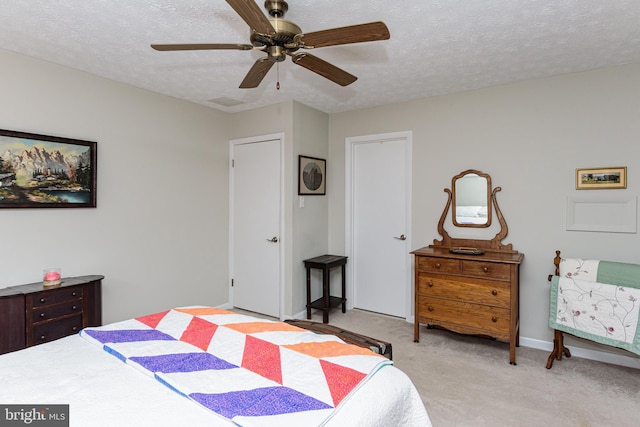 carpeted bedroom featuring a textured ceiling and ceiling fan