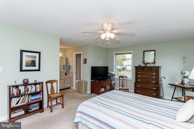 bedroom featuring ceiling fan, light colored carpet, ensuite bathroom, and a textured ceiling