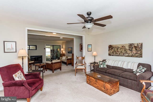 carpeted living room featuring a textured ceiling and ceiling fan