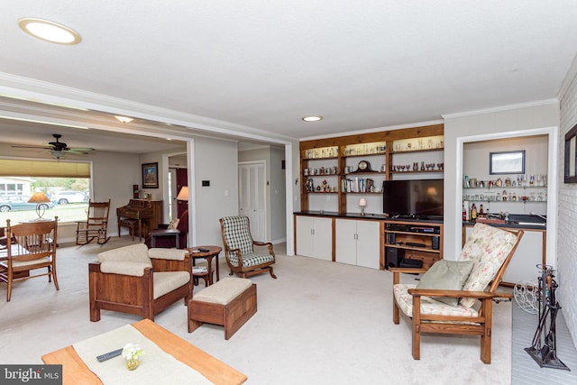 carpeted living room with crown molding, bar, and ceiling fan