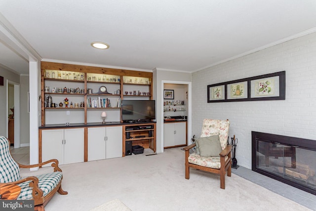 sitting room featuring crown molding, a fireplace, light carpet, and brick wall