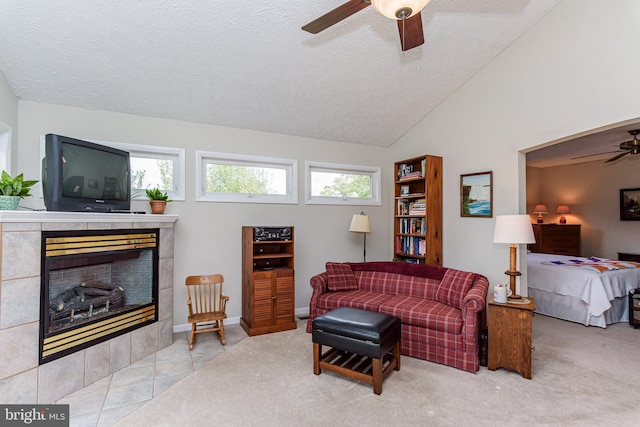 carpeted living room with ceiling fan, a textured ceiling, a fireplace, and plenty of natural light