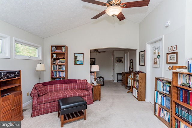 sitting room with light carpet, lofted ceiling, ceiling fan, and a textured ceiling