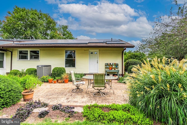 rear view of house featuring solar panels, a patio area, and central air condition unit