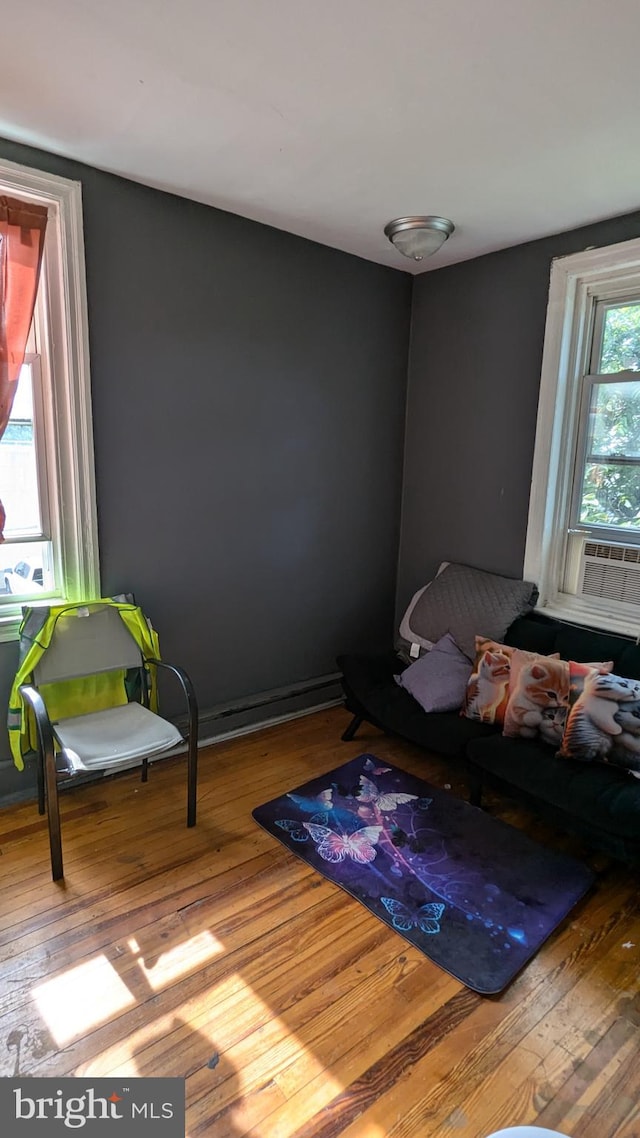 sitting room with cooling unit and hardwood / wood-style flooring