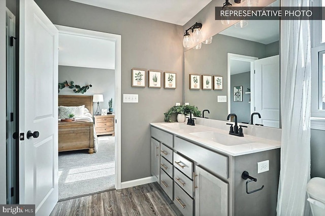 bathroom featuring toilet, hardwood / wood-style flooring, and vanity