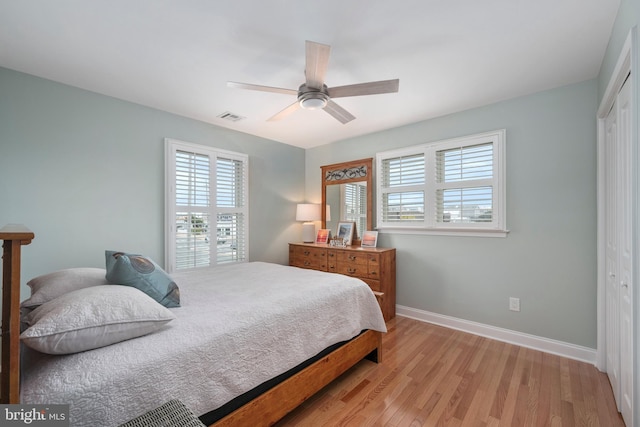 bedroom featuring ceiling fan, light wood-type flooring, and a closet