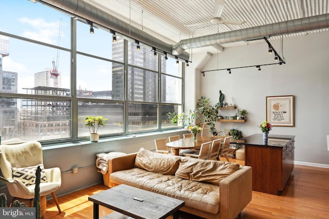 interior space with rail lighting, a view of city, and ceiling fan