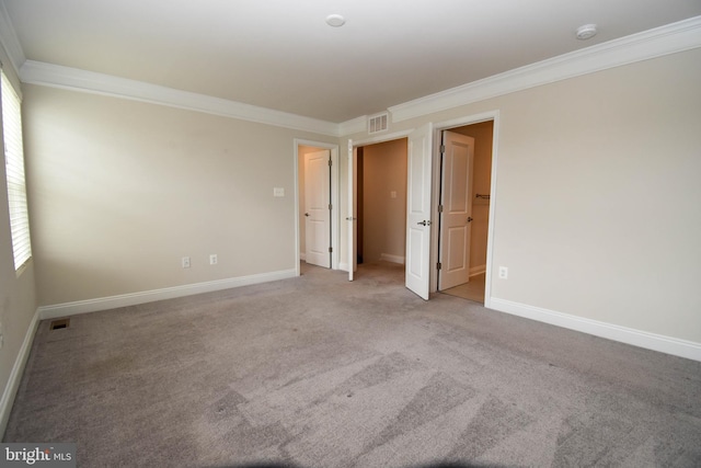 carpeted empty room featuring crown molding