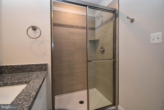 bathroom with a shower with door and vanity