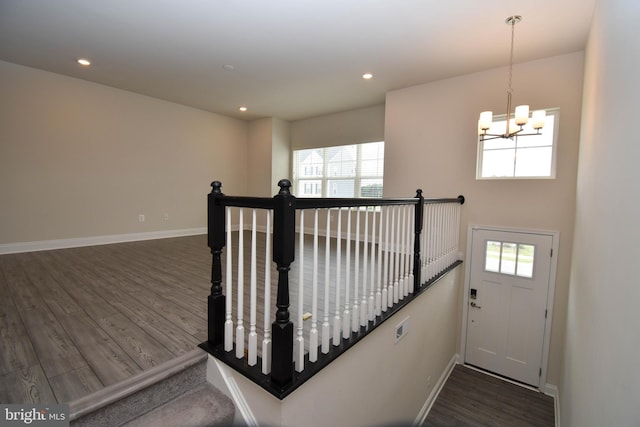 staircase featuring an inviting chandelier, hardwood / wood-style floors, and a wealth of natural light