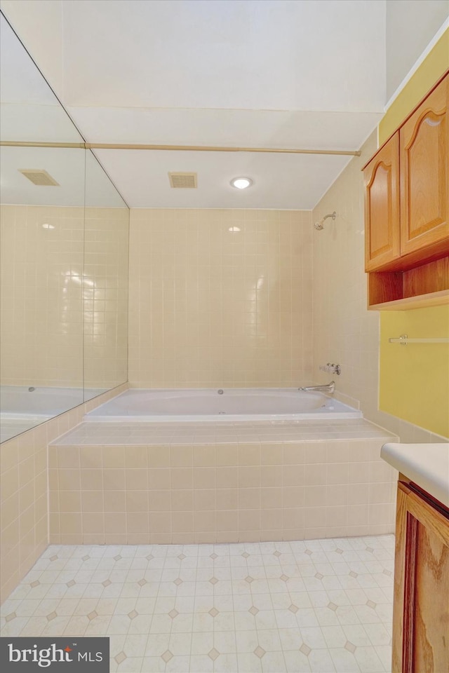 bathroom with tiled shower / bath and vanity