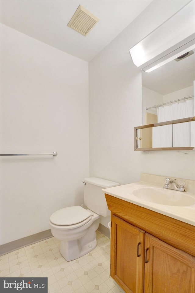 bathroom featuring vanity, toilet, and curtained shower