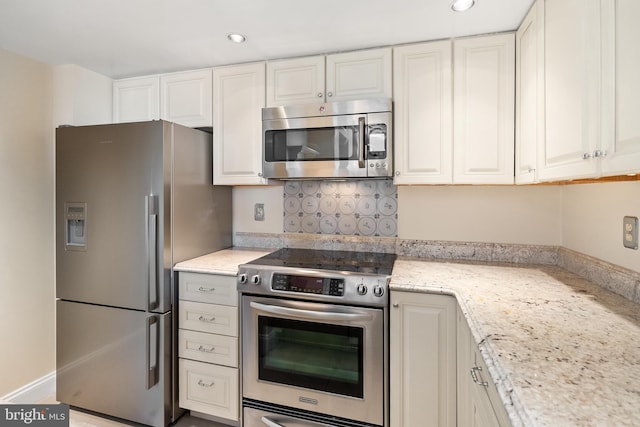 kitchen featuring appliances with stainless steel finishes, white cabinetry, and light stone countertops