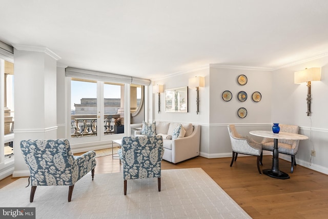 living room with ornamental molding, light wood-type flooring, and baseboards