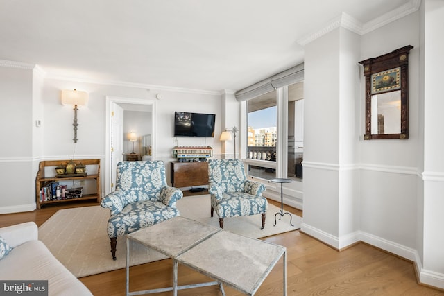 living room with baseboards, wood finished floors, and crown molding