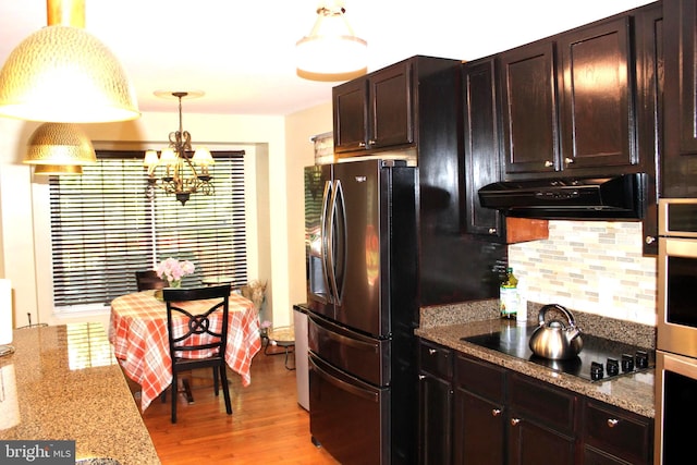 kitchen with light hardwood / wood-style flooring, a notable chandelier, black electric cooktop, extractor fan, and stainless steel fridge with ice dispenser