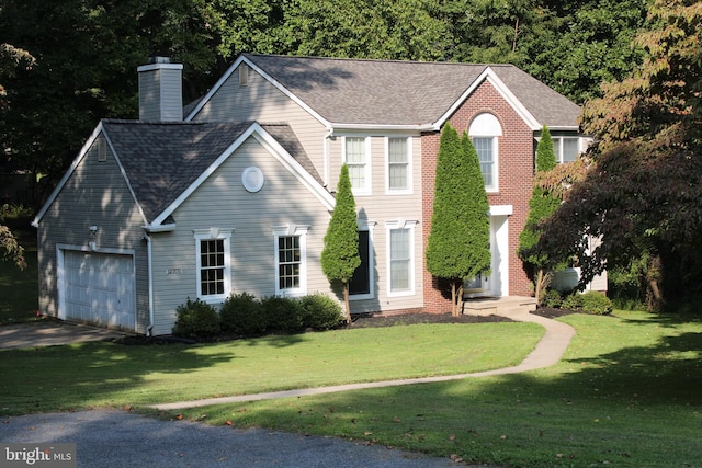 colonial-style house with a front yard and a garage