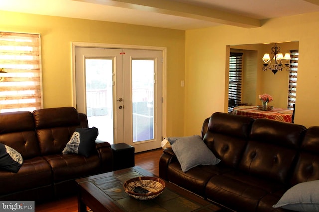 living room with hardwood / wood-style flooring, plenty of natural light, an inviting chandelier, and beam ceiling