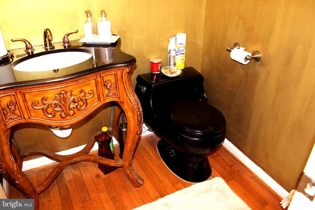 interior space featuring vanity, toilet, and hardwood / wood-style floors