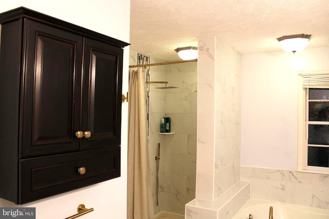 bathroom with a textured ceiling and shower with separate bathtub