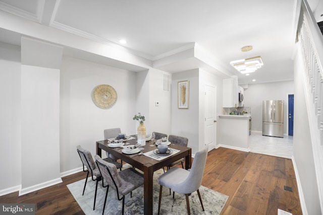 dining area with ornamental molding and dark hardwood / wood-style flooring