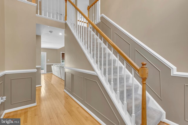 stairs with a high ceiling and hardwood / wood-style floors