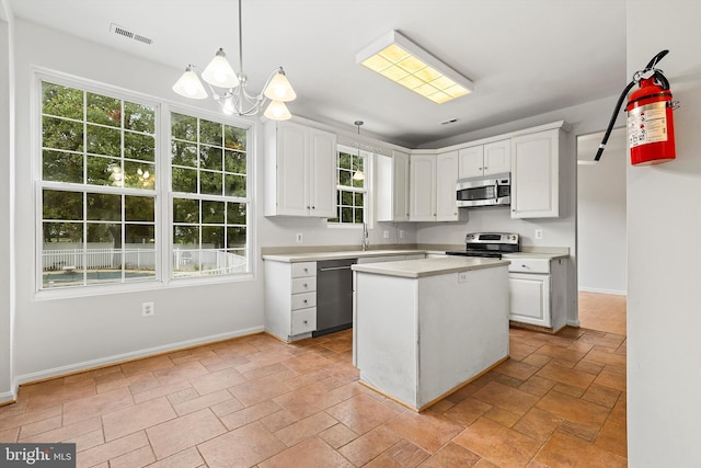 kitchen featuring white cabinets, a wealth of natural light, appliances with stainless steel finishes, and hanging light fixtures