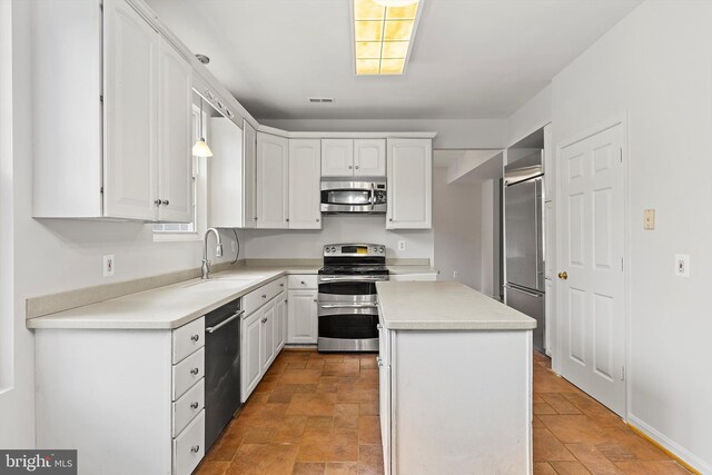 kitchen with hanging light fixtures, sink, a kitchen island, white cabinetry, and stainless steel appliances