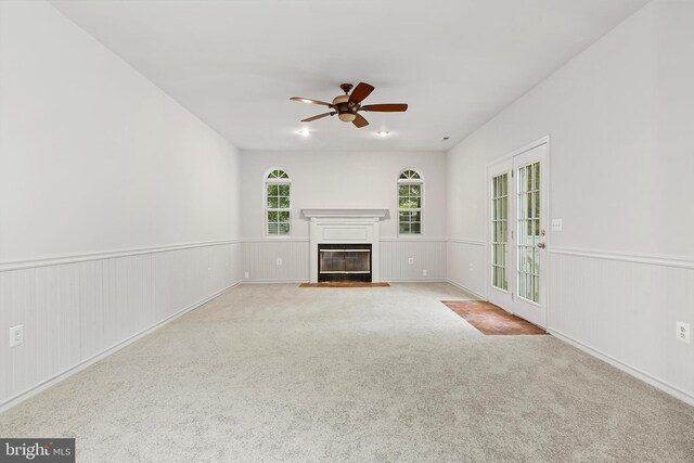 unfurnished living room with light carpet and ceiling fan