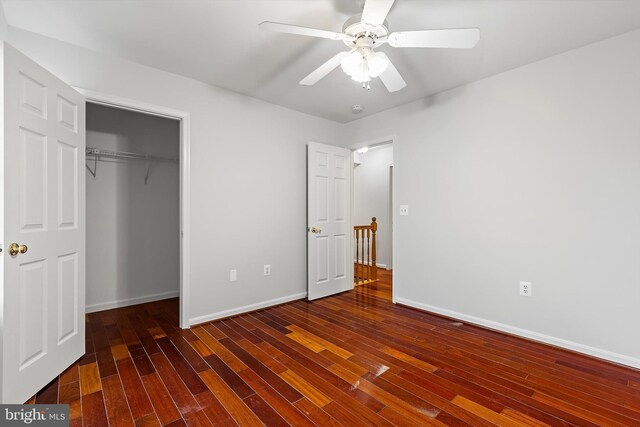 unfurnished bedroom featuring dark hardwood / wood-style flooring, ceiling fan, and a closet