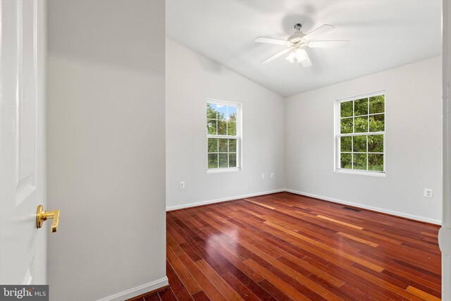 spare room with vaulted ceiling, dark hardwood / wood-style floors, and ceiling fan