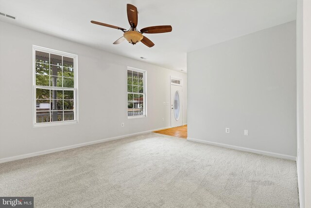 carpeted spare room with ceiling fan