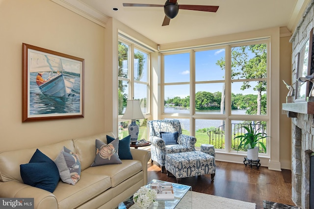 living room with ceiling fan, ornamental molding, a fireplace, and dark hardwood / wood-style flooring