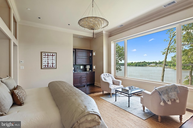 bedroom featuring a water view, multiple windows, hardwood / wood-style flooring, and sink